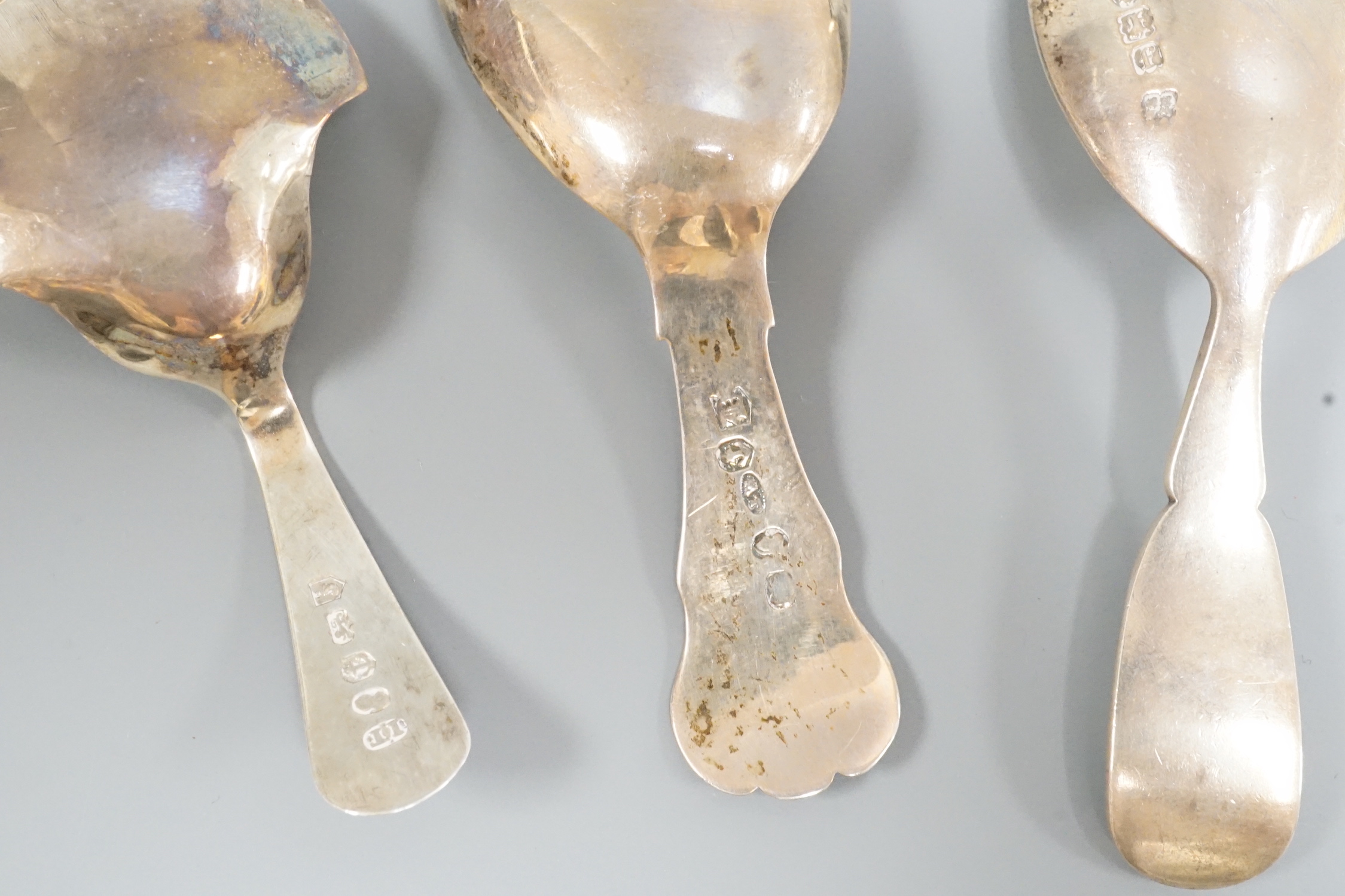 Two 19th century silver caddy spoons, including Birmingham, 1827, one later caddy spoon and an ornate Dutch white metal serving spoon.